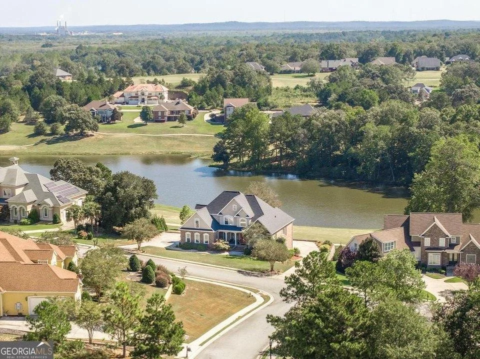 Homes and tree-lined streets surrounding a neighborhood pond